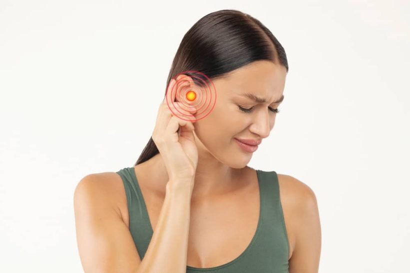 young woman frowning from strong ear pain